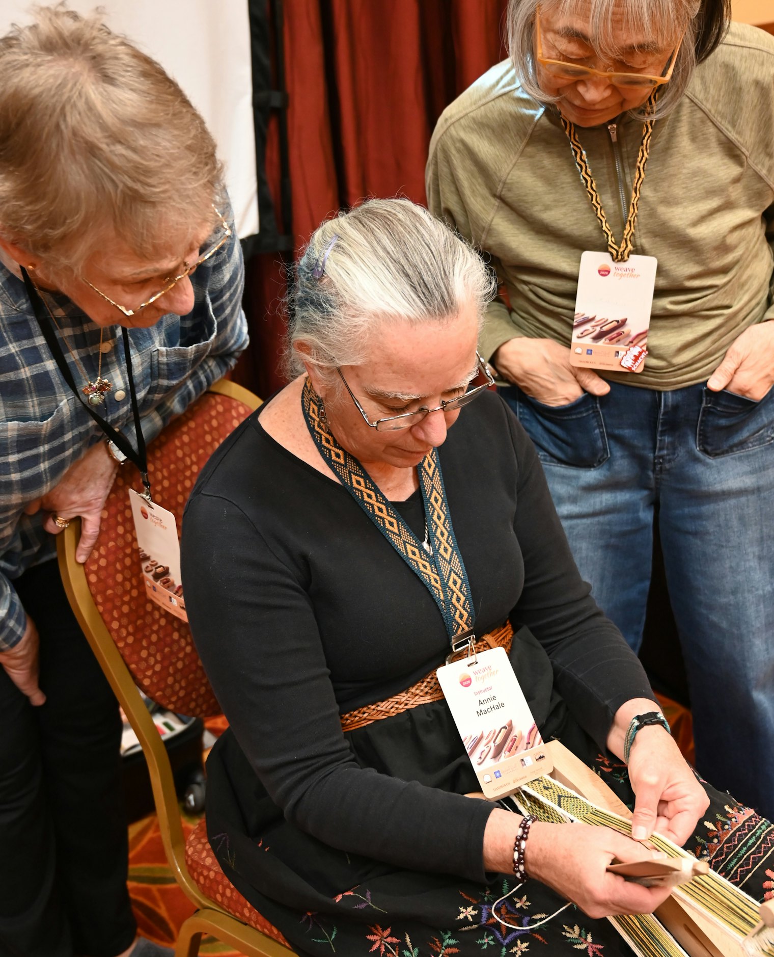 Annie MacHale demonstrates three-color bandweaving techniques to students at Weave Together 2026.