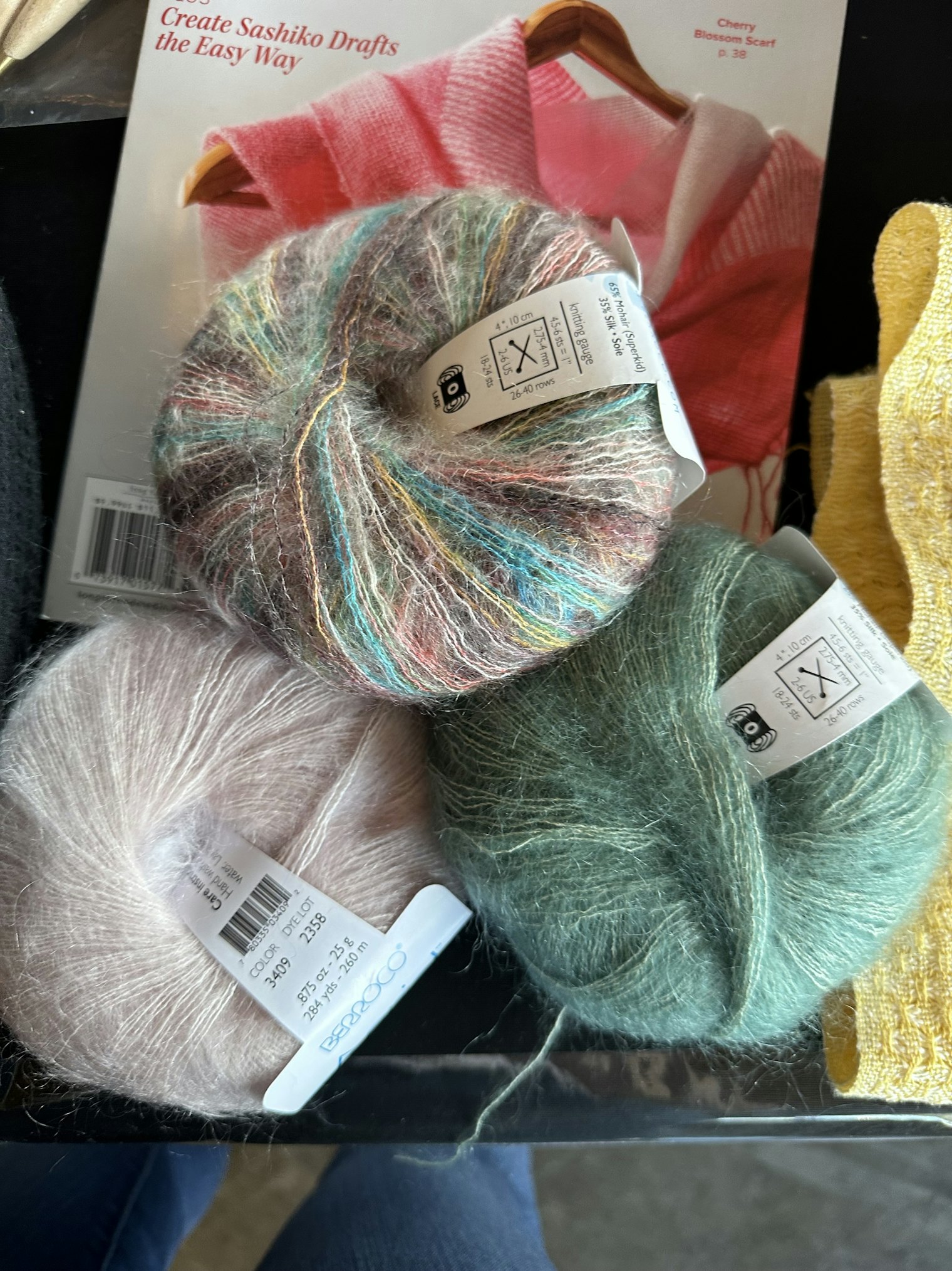 Three balls of mohair yarn in a color photo.