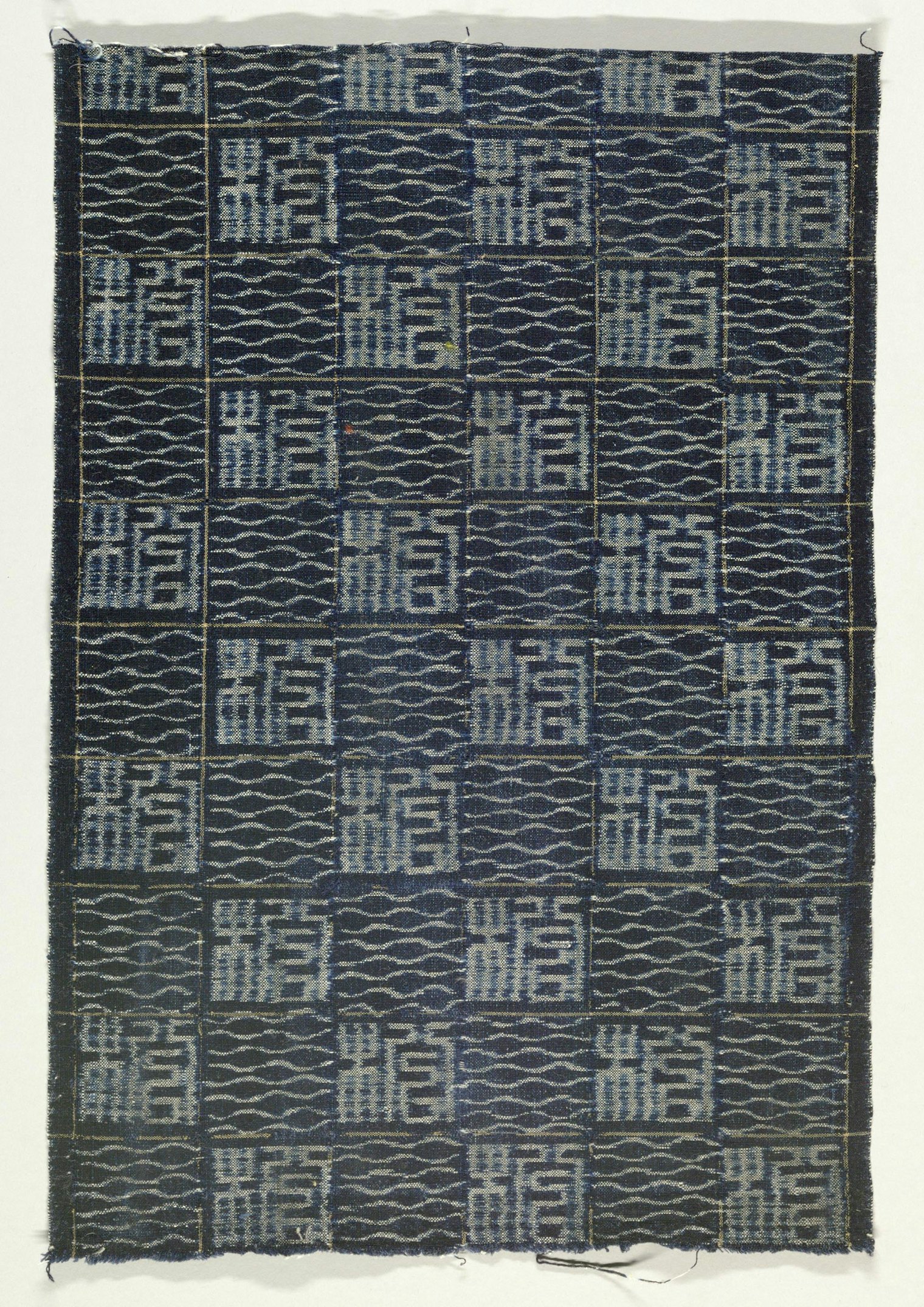 Textile with checkerboard design of two alternating geometric patterns created in the weft ikat or kasuri technique. Cotton, indigo dyed, plain weave. Pattern described as "seal script." Source: Narumi, Honshu, Japan. Late 19th Century. Courtesy of Cooper Hewitt, CC0 license
