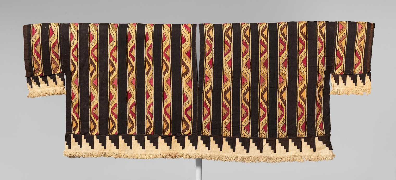 Finely woven shirt, made from camelid fibers and cotton, from Peru’s central coast. This garment was woven in two parts that were later joined by seams at the sides and top, leaving openings for the head and arms. The lower fringed band and sleeves were made separately and subsequently attached. 1460–1540 CE. Courtesy of Metropolitan Museum of Art, CC0 license