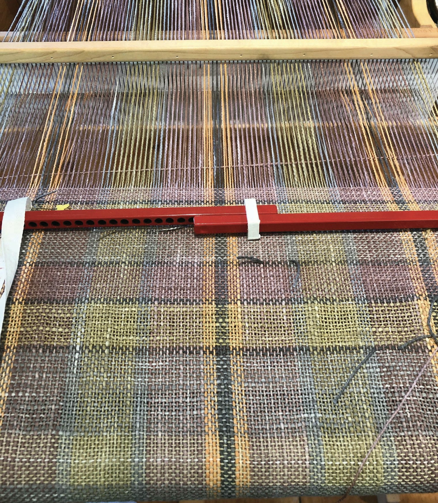 Elisabeth warped her rigid-heddle loom and wove with the mud-dyed yarns immediately after drying.