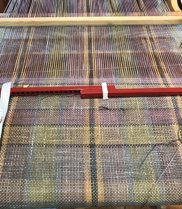 Elisabeth warped her rigid-heddle loom and wove with the mud-dyed yarns immediately after drying.