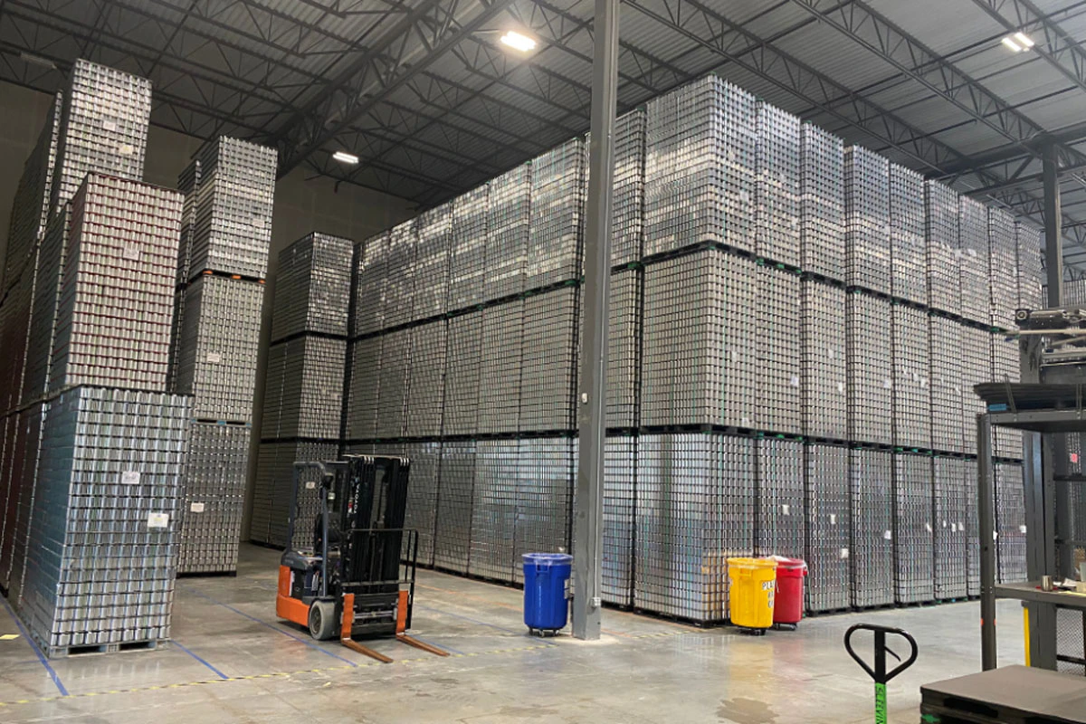 A temperature-controlled warehouse filled with stacked beer cans.