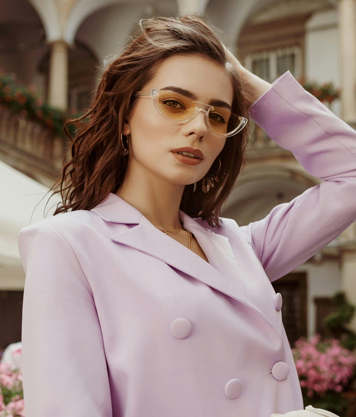 Young sexy woman in light violet jacket playing with her hair.