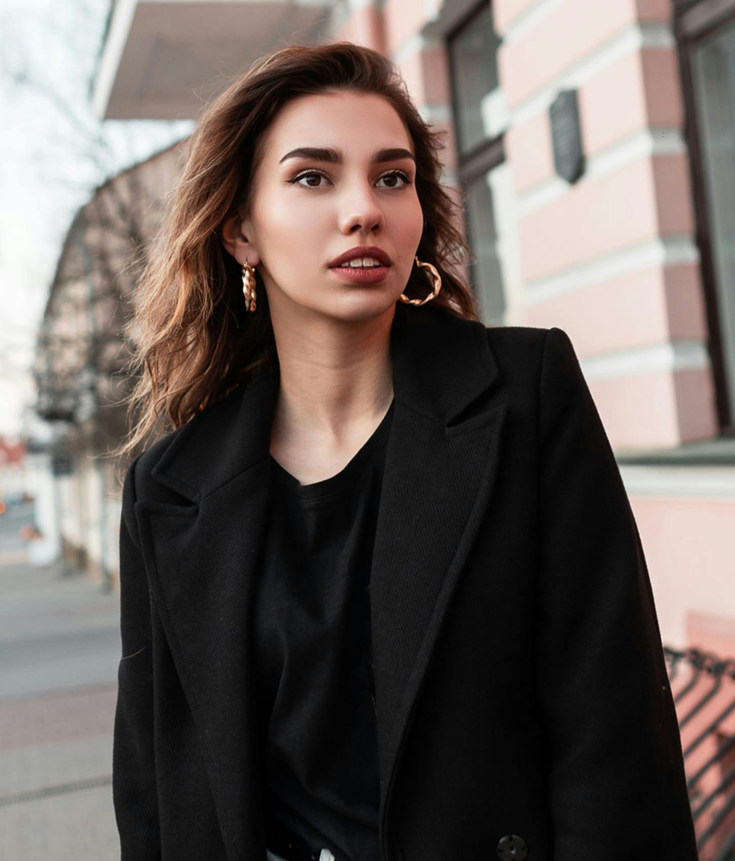woman in a black coat and nice makeup.