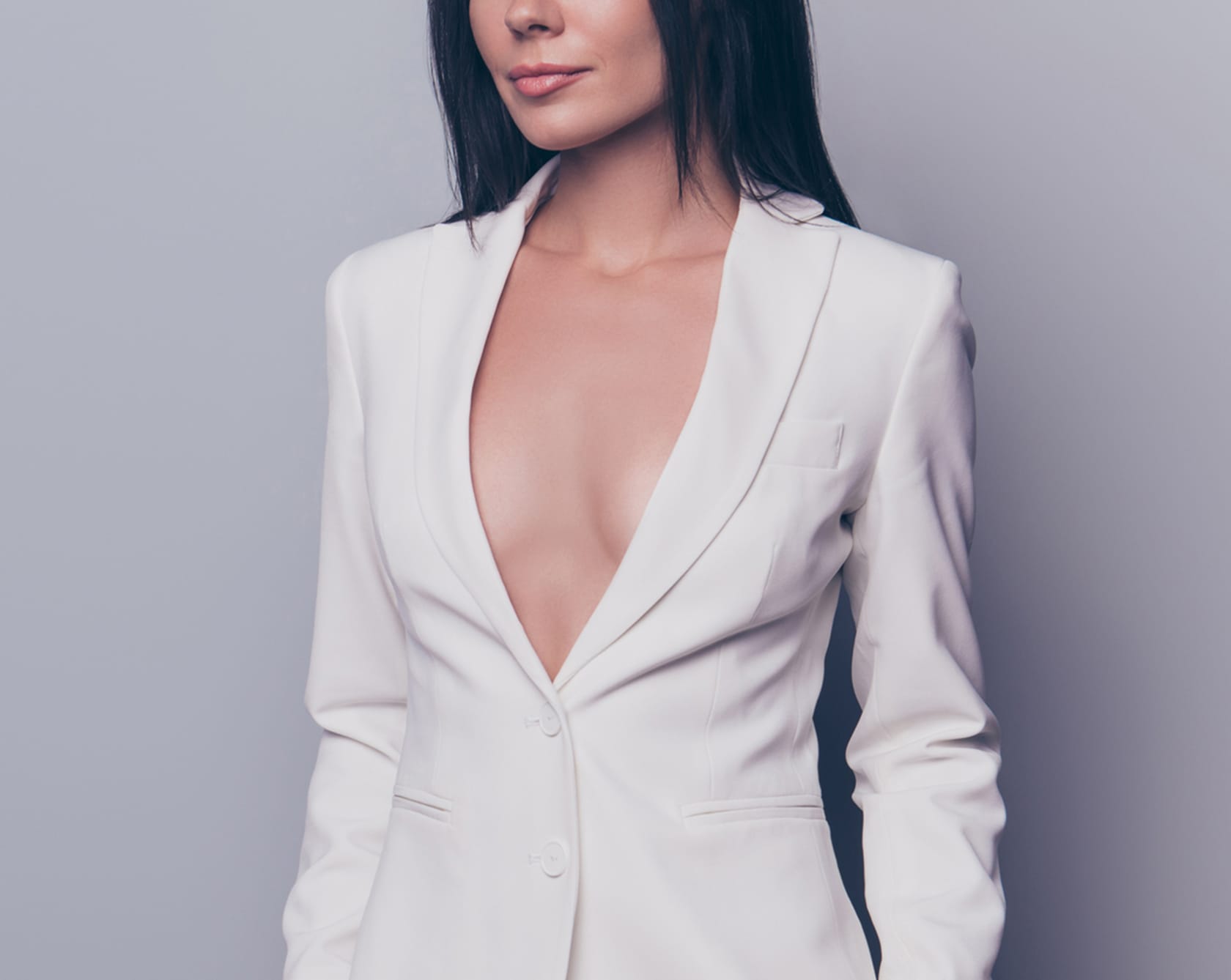 slim attractive woman in a white jacket with her upper chest exposed
