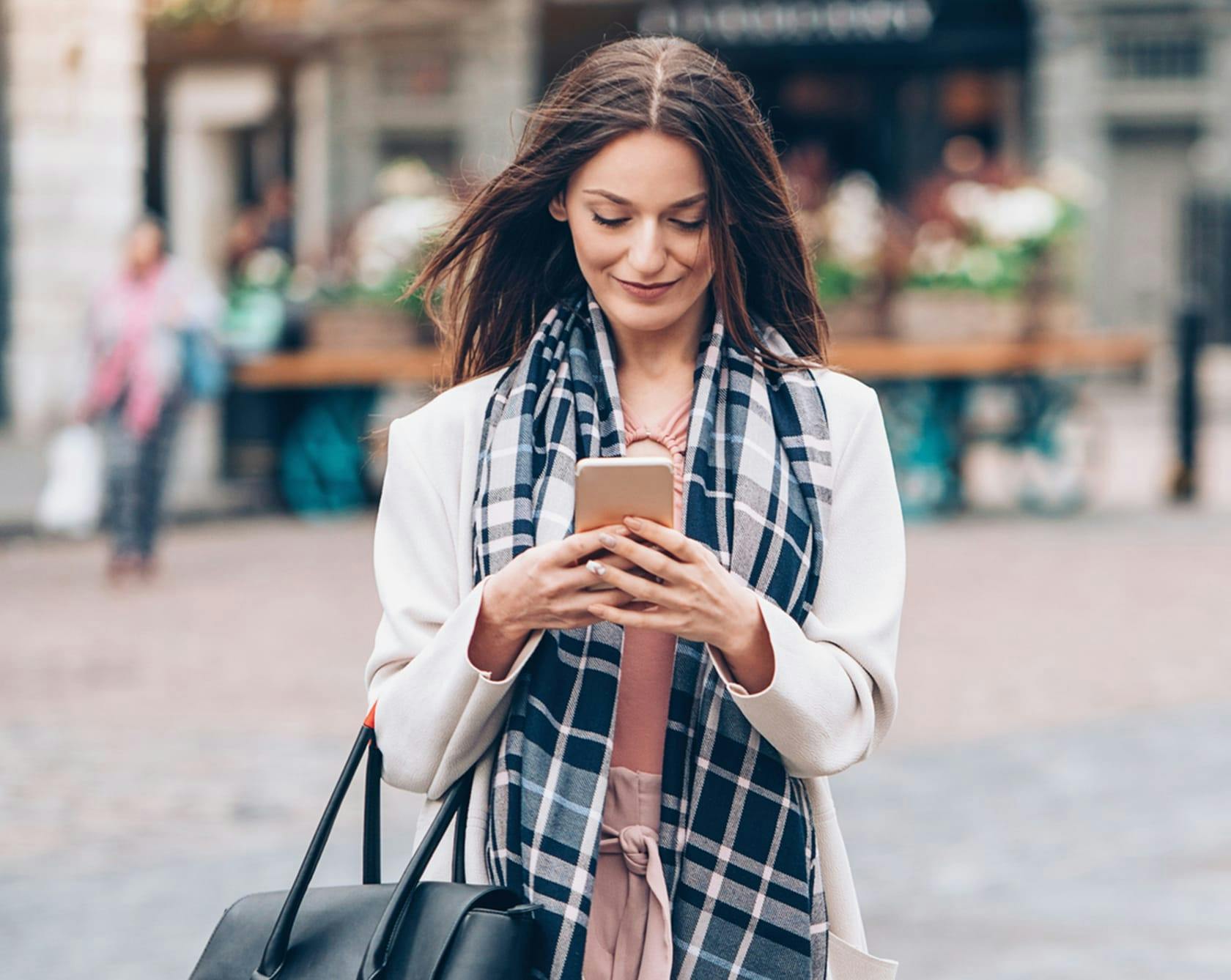 good looking woman looking at her phone and smiling.