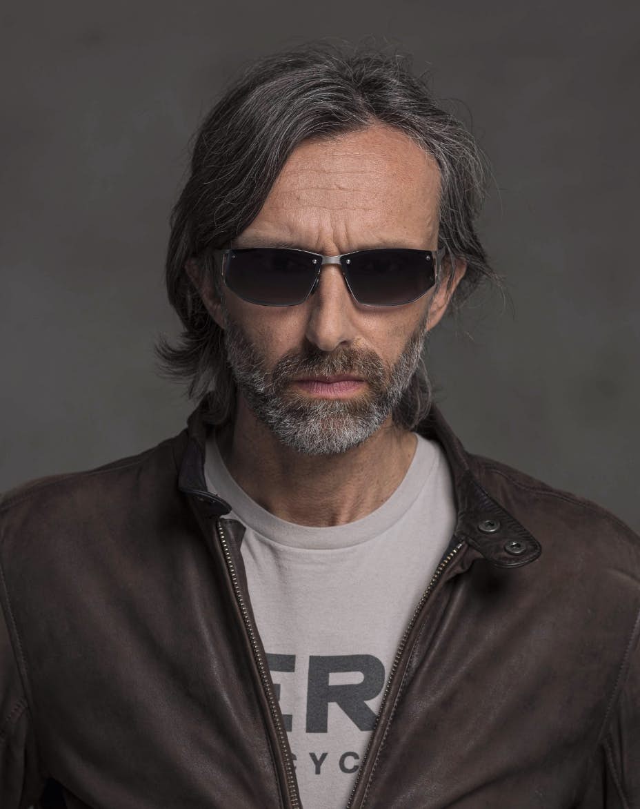 The model is wearing Cosmic Palladium glasses with smoke lenses