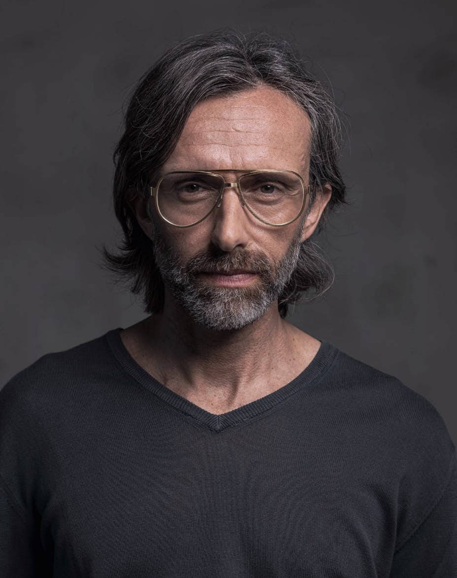 The model is wearing Serpico Gold glasses with vision lenses