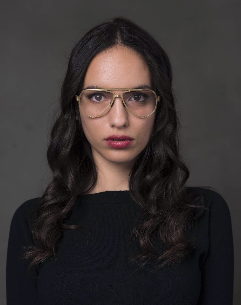 The model is wearing Serpico Gold glasses with vision lenses