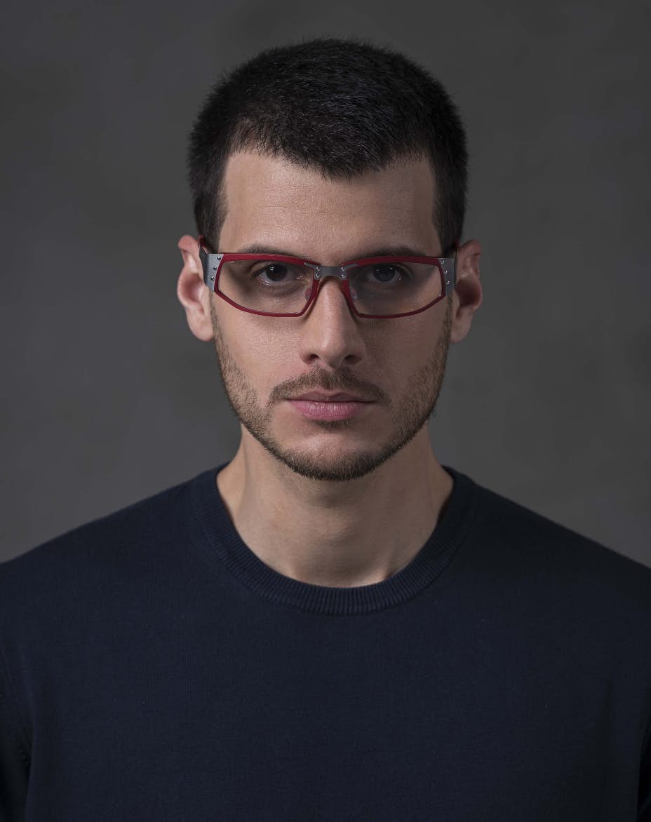 The model is wearing Touring 960 Red glasses with vision lenses