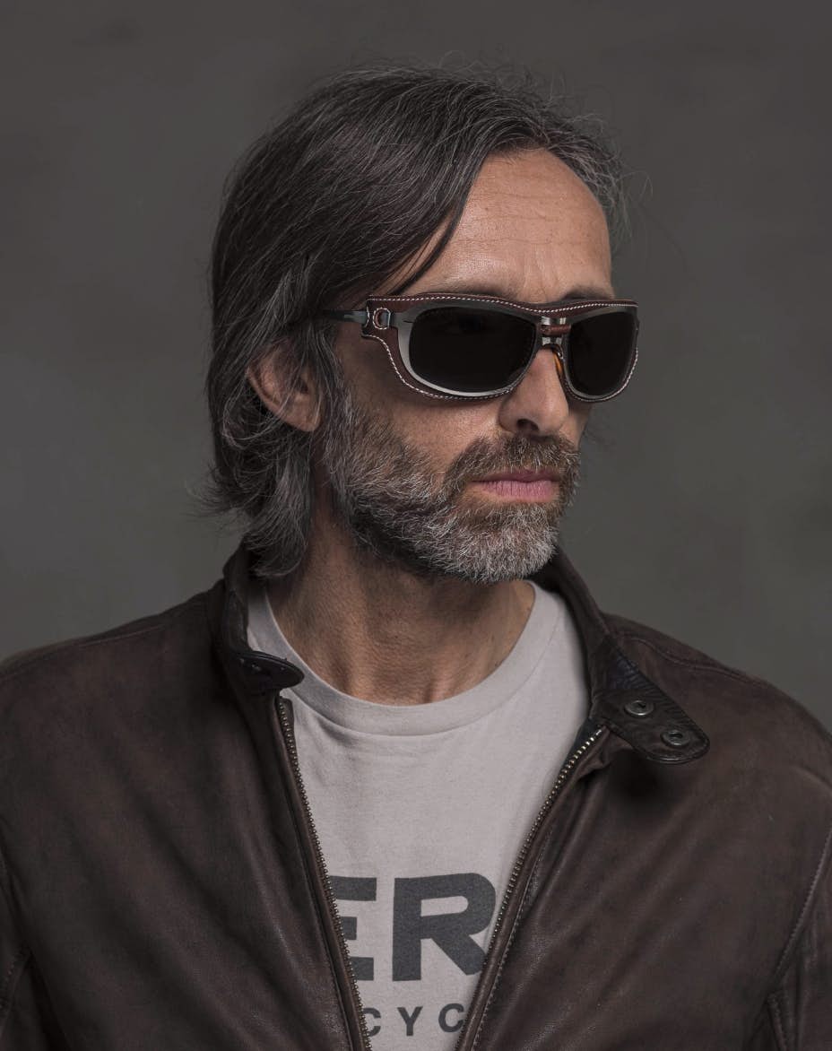 The model is wearing Special Custom Palladium glasses with smoke lenses and brown front cover