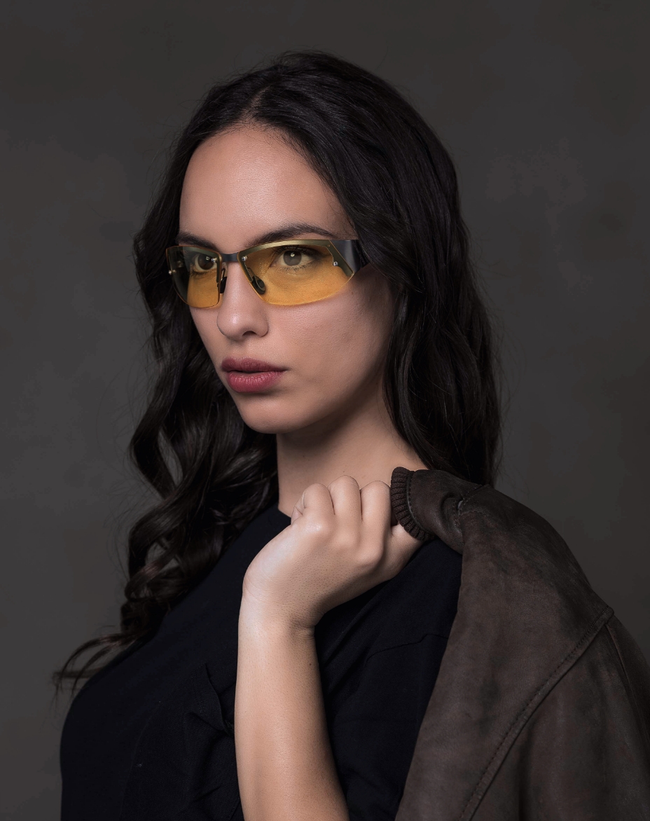 The model is wearing Gran Turismo Titanium glasses with yellow lenses
