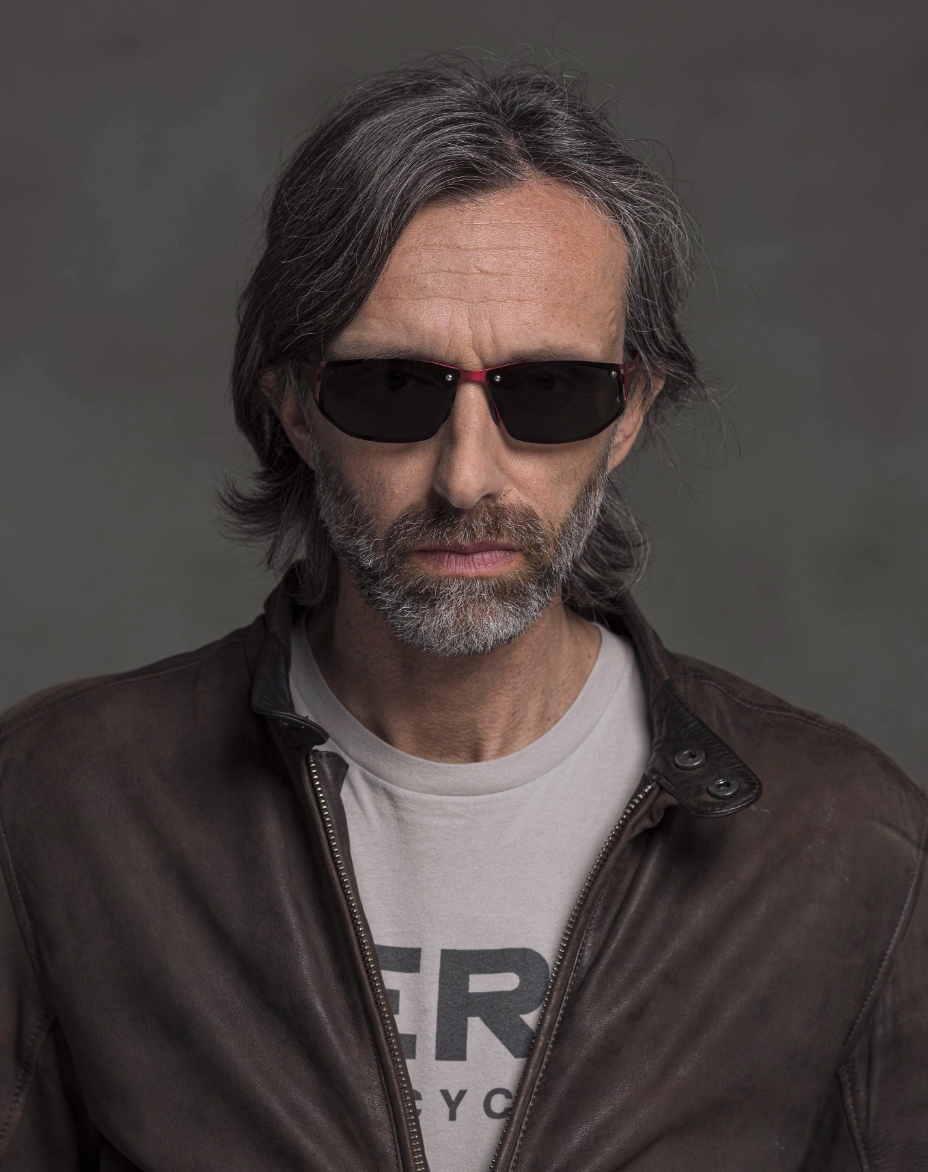 The model is wearing Cosmic Red glasses with smoke lenses