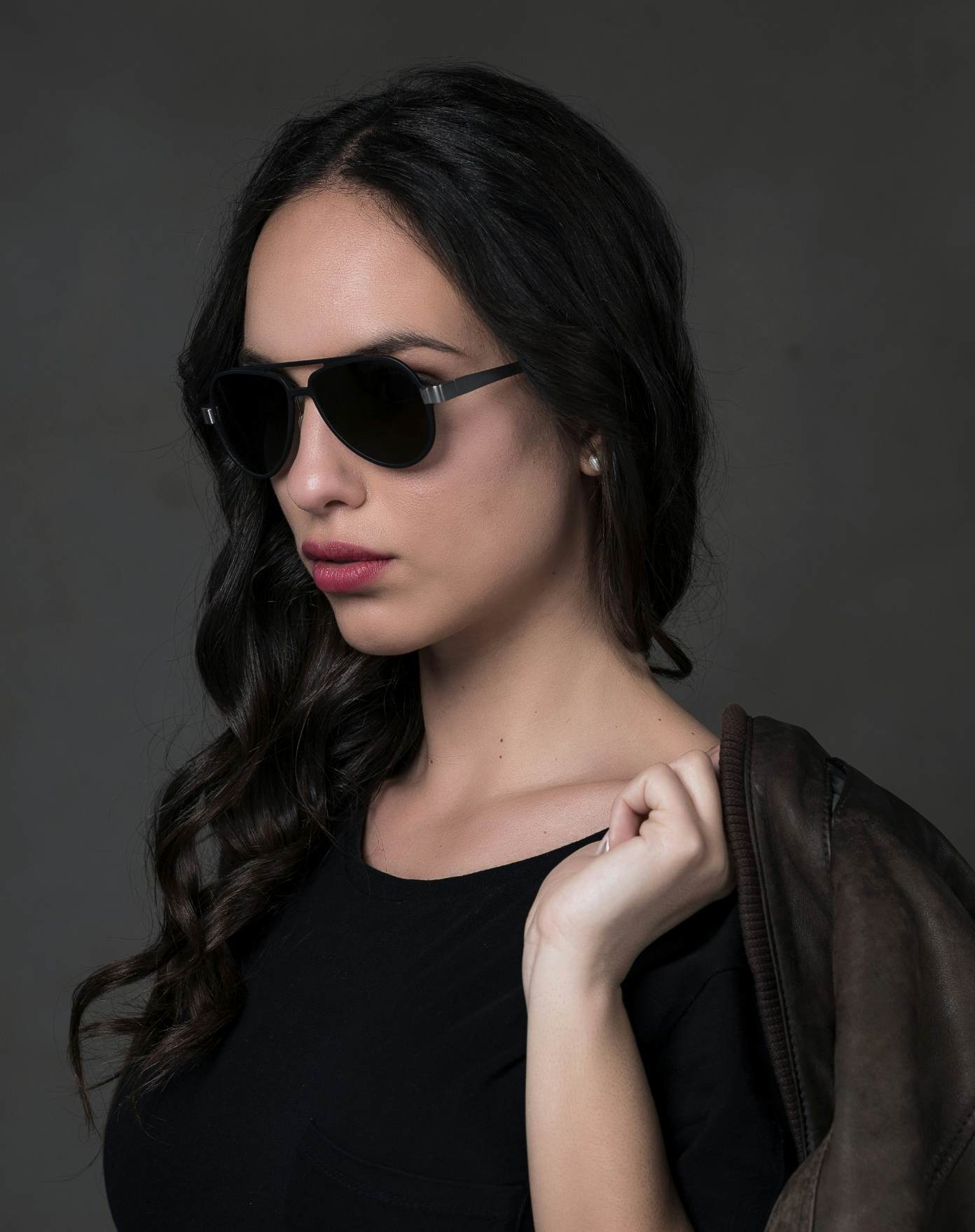 La modella indossa gli occhiali 820 con aste titanio sabbiato, fontale nero e lenti color fumo