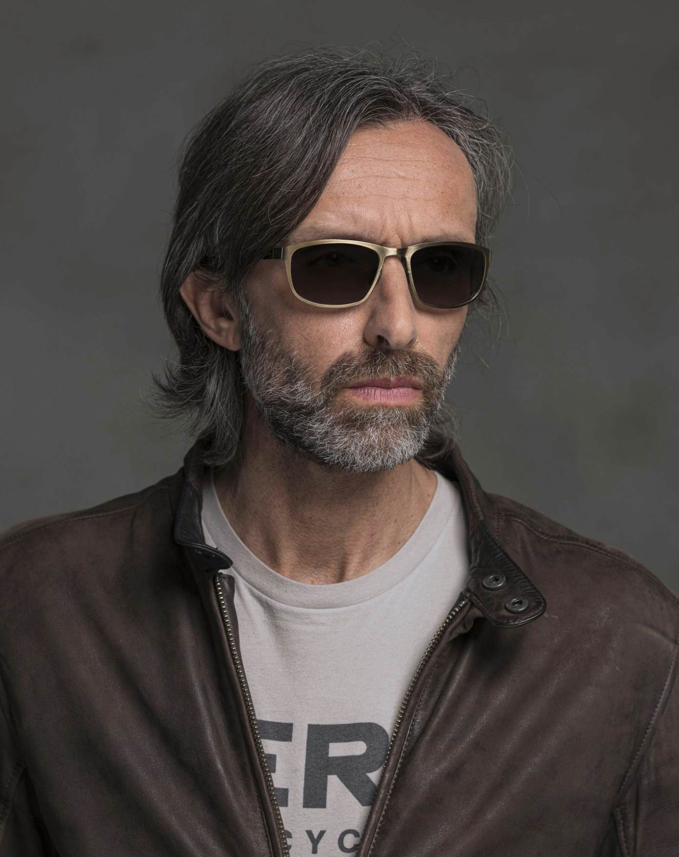 The model is wearing Atom Bronze glasses with smoke lenses