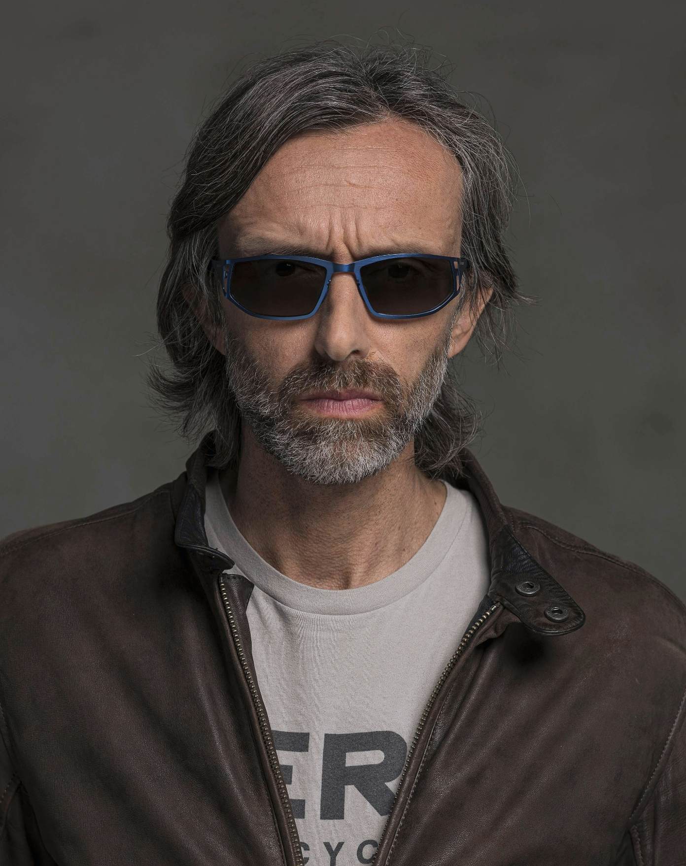 The model is wearing Dynamic Dark Blue glasses with smoke lenses