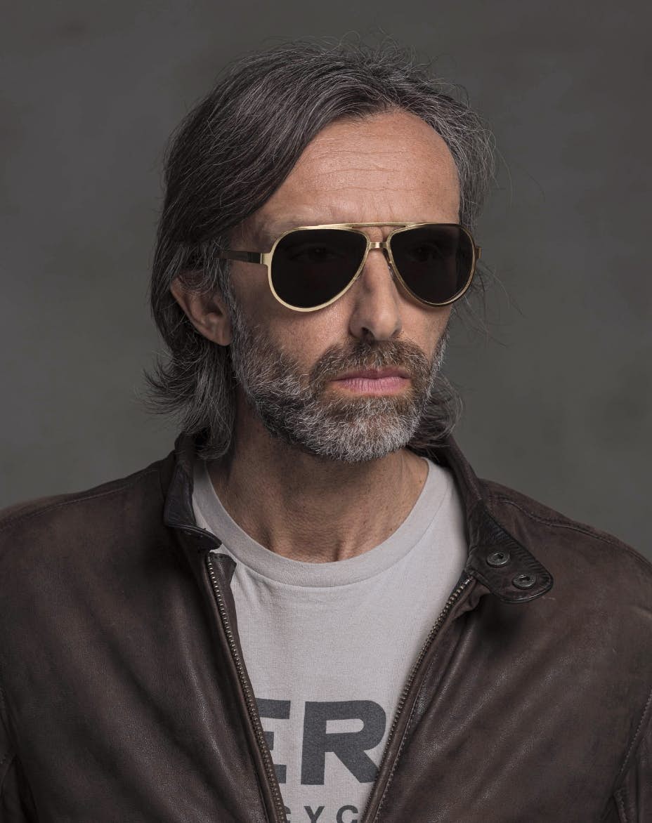 The model is wearing Serpico Gold glasses with smoke lenses