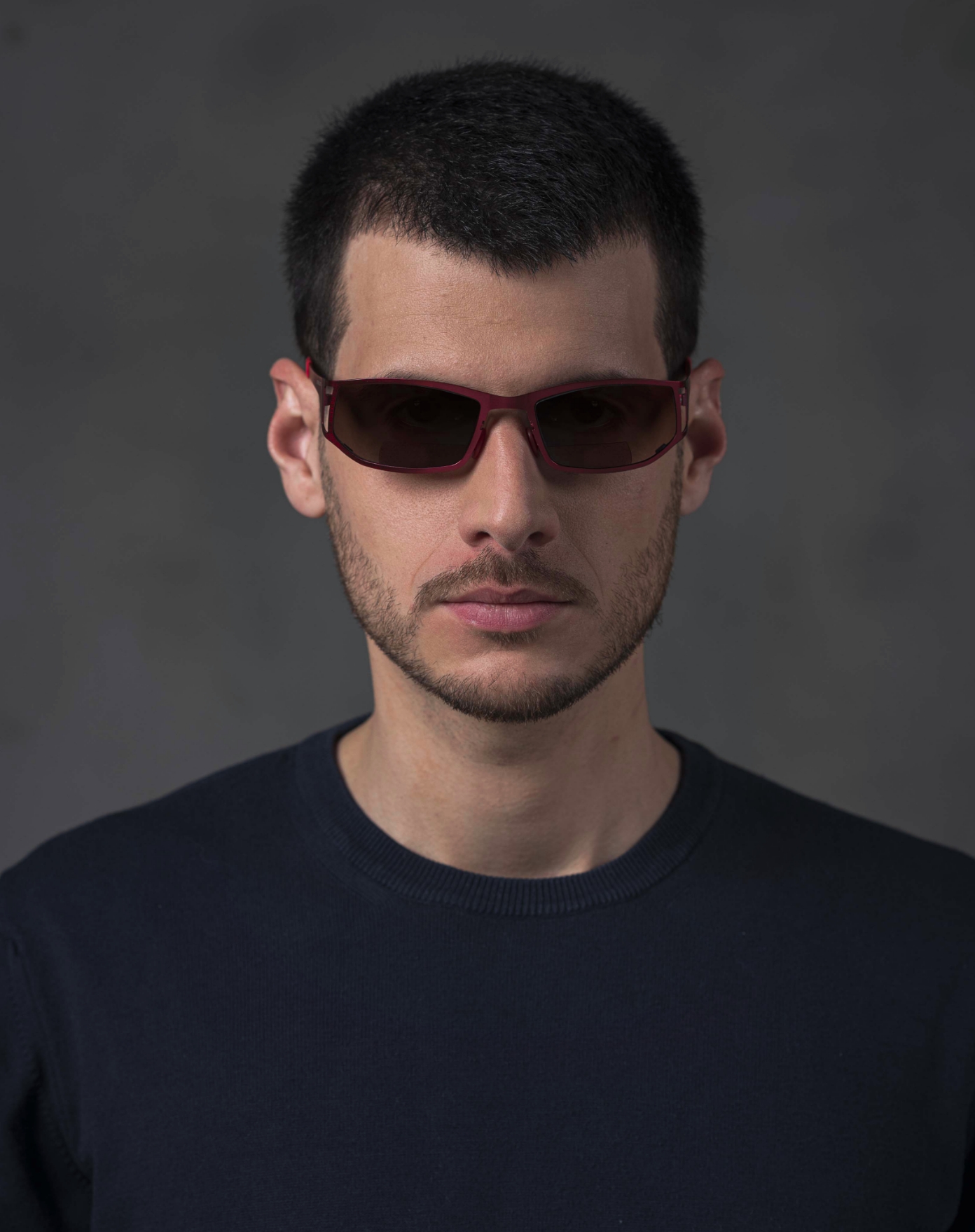 The model is wearing Dynamic Red glasses with smoke lenses