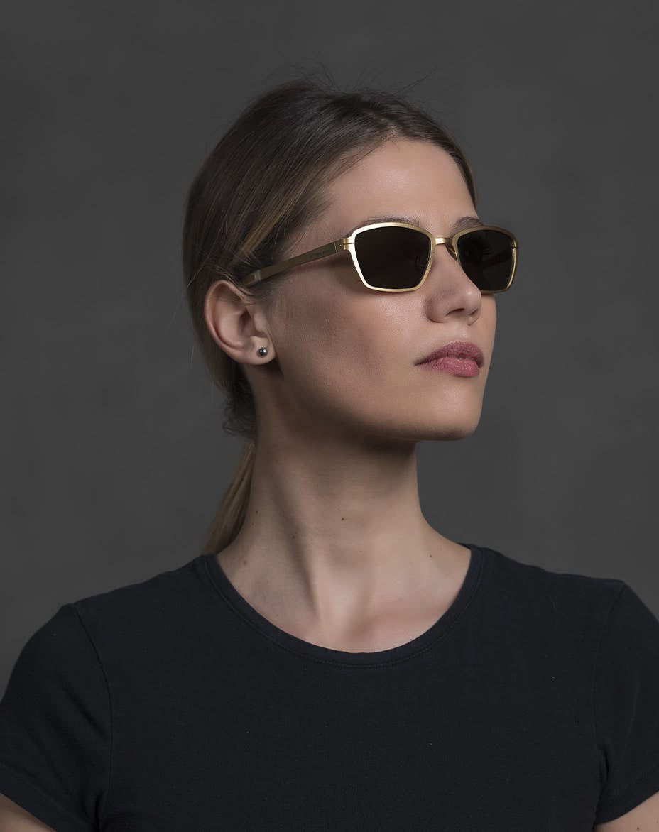 The model is wearing Pin Up Gold glasses with smoke lenses