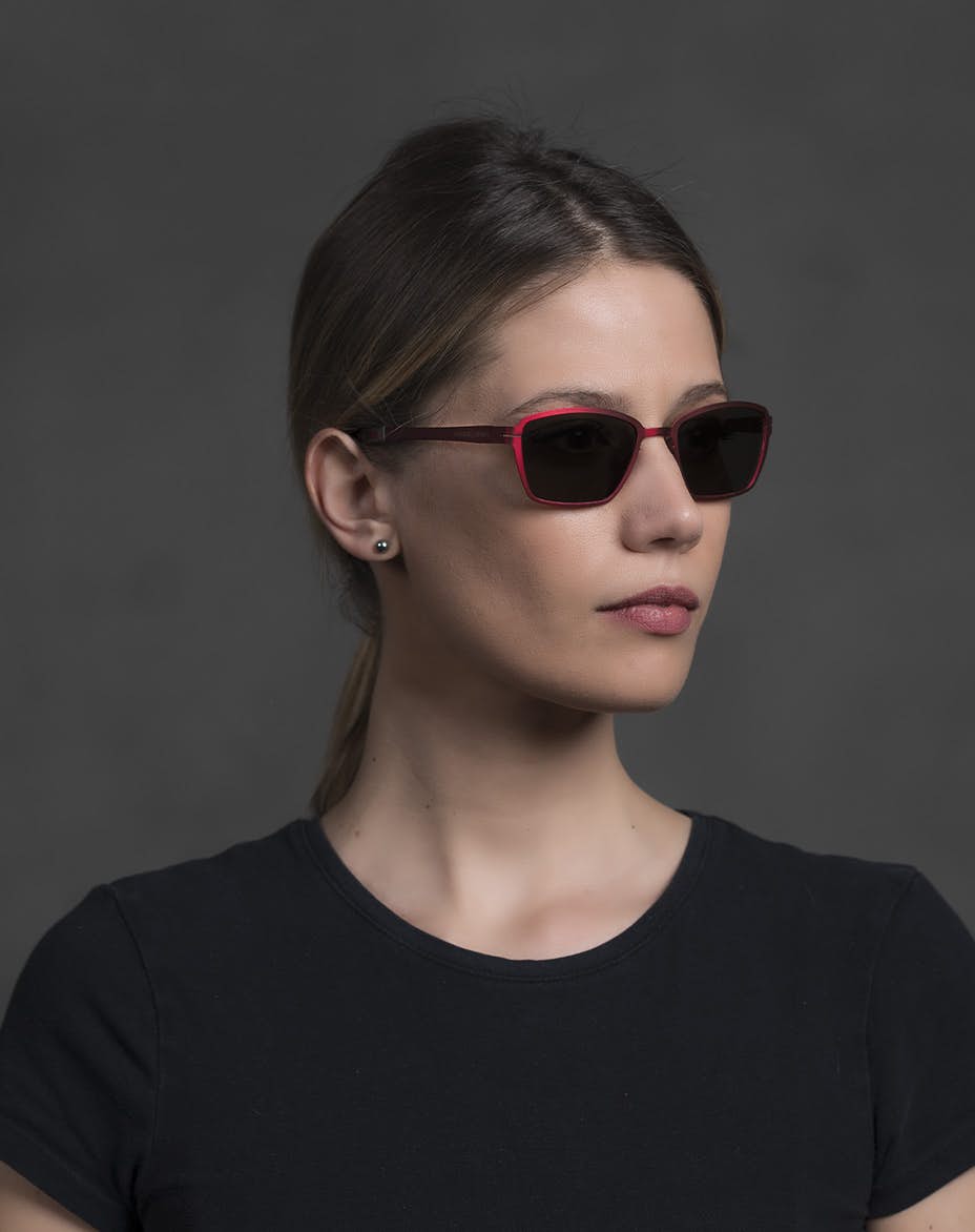 The model is wearing Pin Up Red glasses with smoke lenses