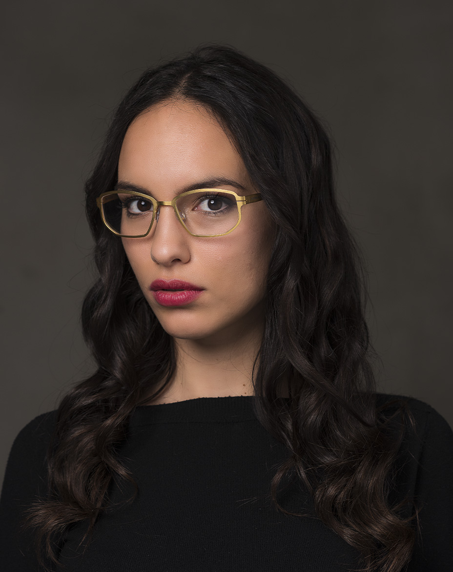 The model is wearing Universal Gold glasses with vision lenses