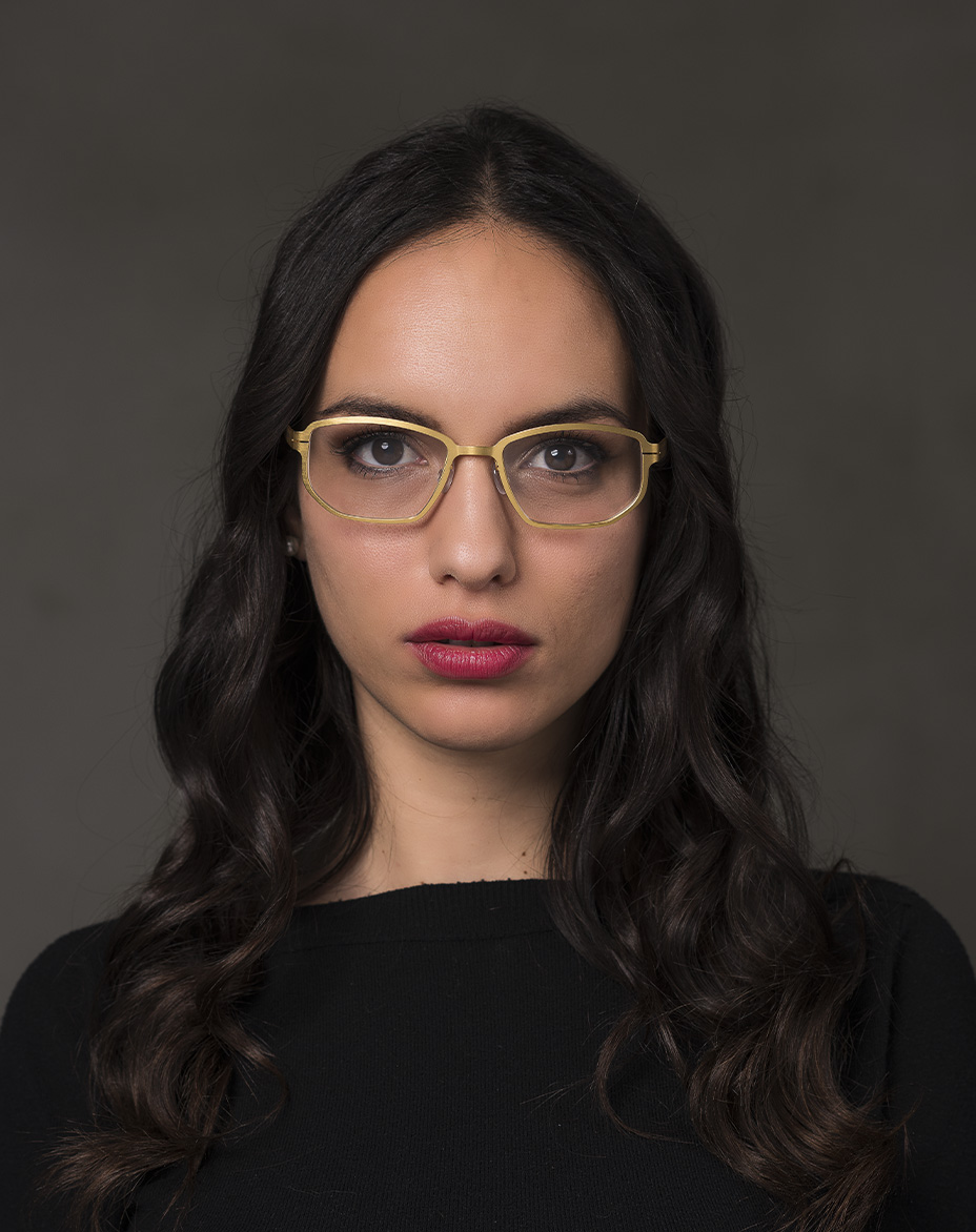 The model is wearing Universal Gold glasses with vision lenses
