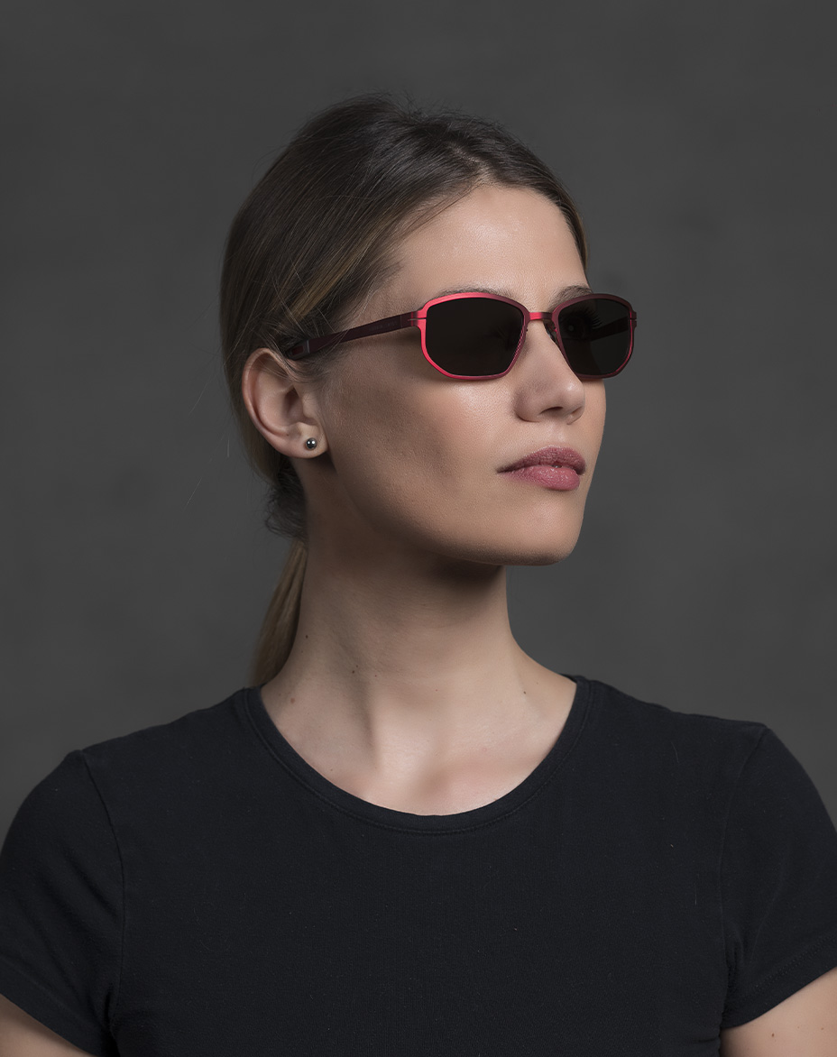 The model is wearing Universal Red glasses with smoke lenses