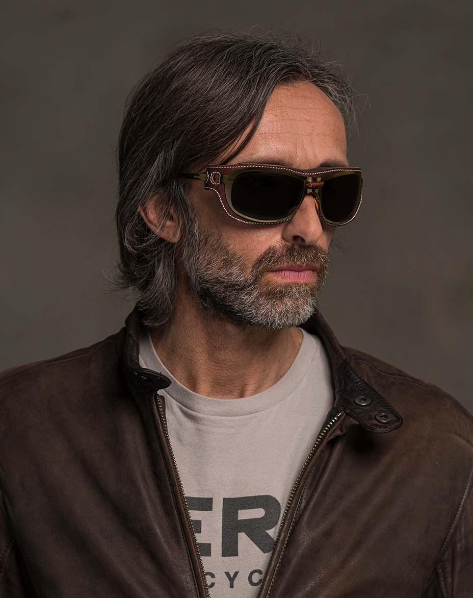 The model is wearing Special Custom Gold glasses with smoke lenses and brown front cover