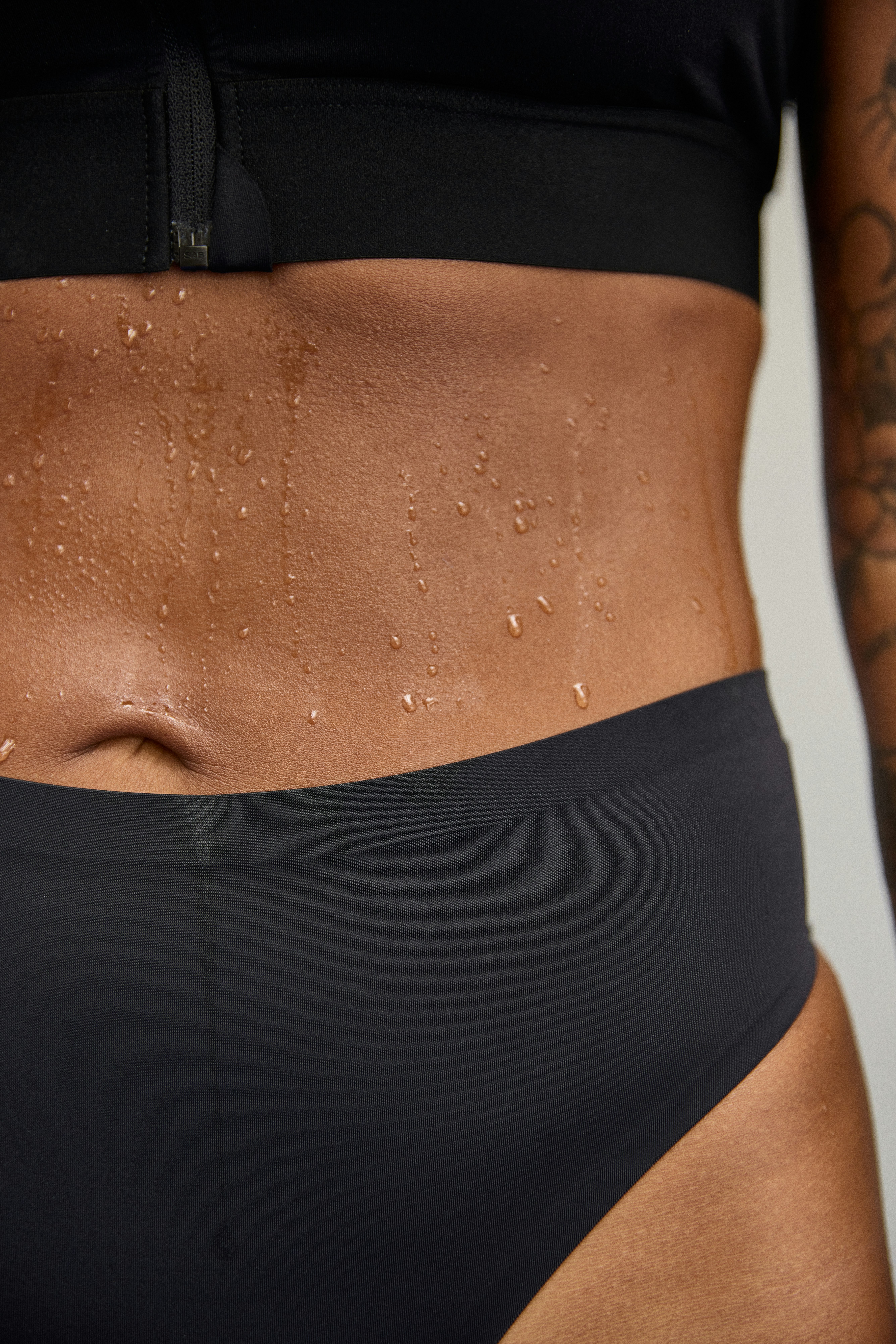 A close up image on a woman in black high waist period panty thong.