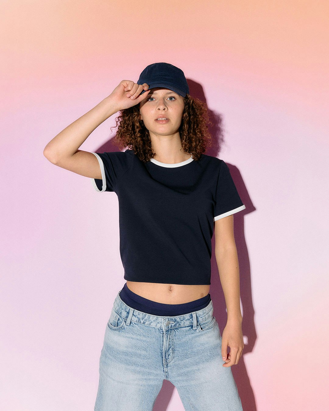En person iført en mørk t-skjorte og lys jeans.