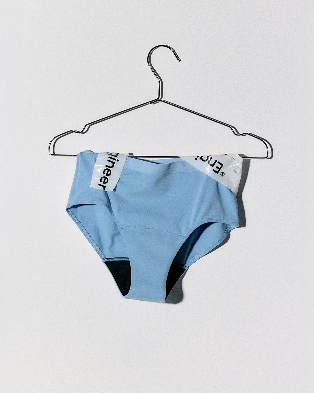 Lys blå menstruser hengt opp på en kleshenger.