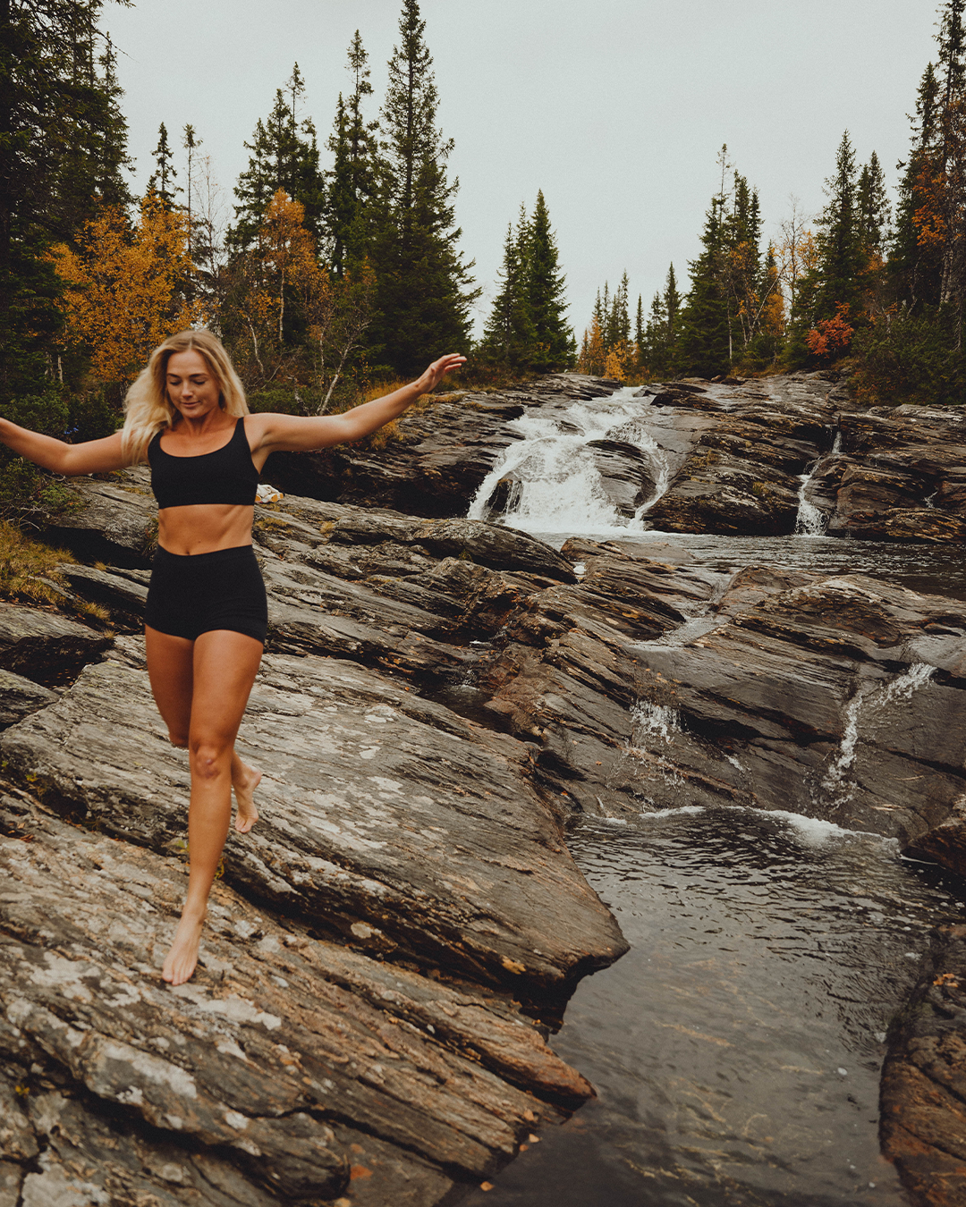 Woman running in period proof swimwear next to a stream