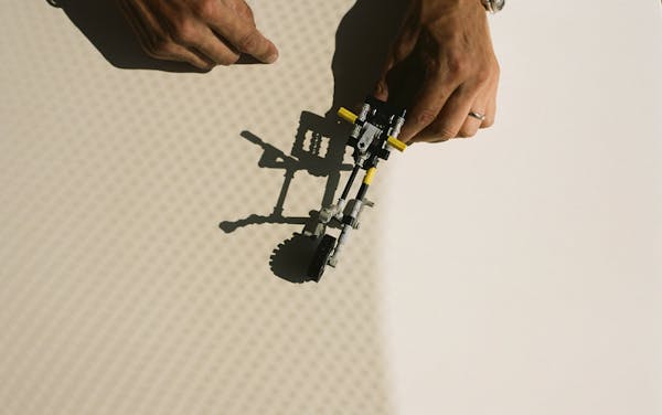 Hands playing with a lego bicycle