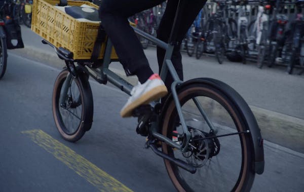 Man riding MONoPOLE No O1 on the street (backside view)