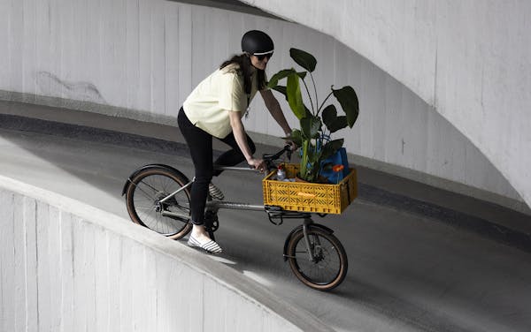 Woman riding cargo bike carrying plants