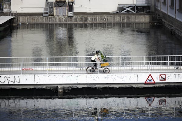 woman riding cargo bike over a bridge