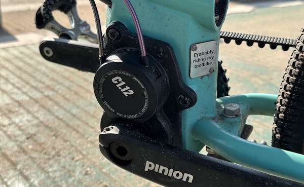 Close-up of the C1.12 Pinion gearbox, and a personalized MONoPOLE plate that reads 'Probably riding my toolbike'.