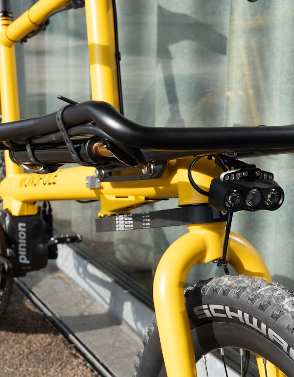 MONoPOLE custom yellow cargo e-bike with Pinion gearbox, Platform front rack, and kLite Ultra V2 front light.
