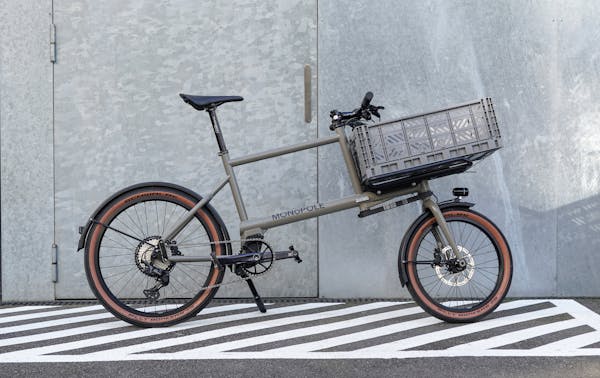MONoPOLE grey compact cargo bike featuring a grey crate on the front.