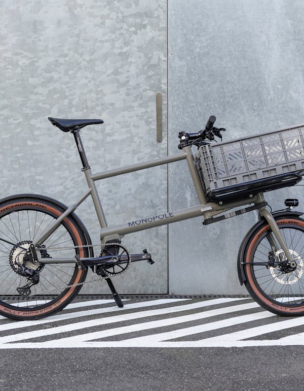 MONoPOLE grey compact cargo bike featuring a grey crate on the front.