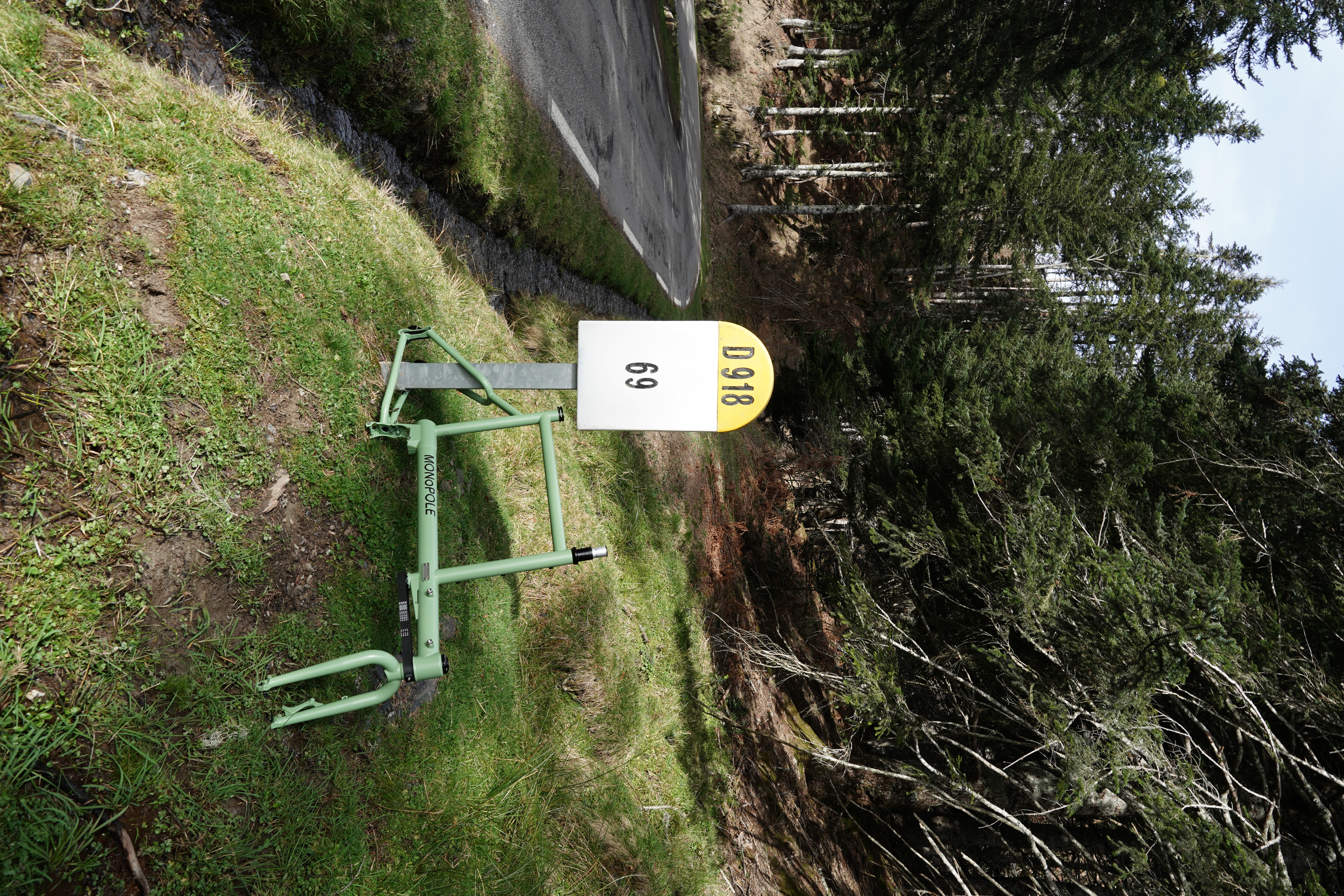 Frameset positioned on the side road of a wooded area, surrounded by trees