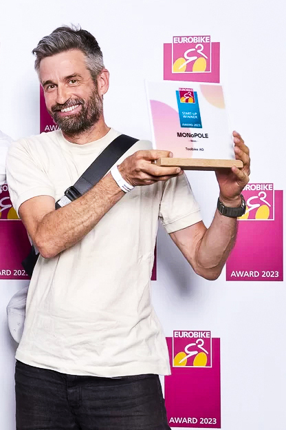 Daniel Freitag at Eurobike 23 holding MONoPOLE's EB START-UP Award