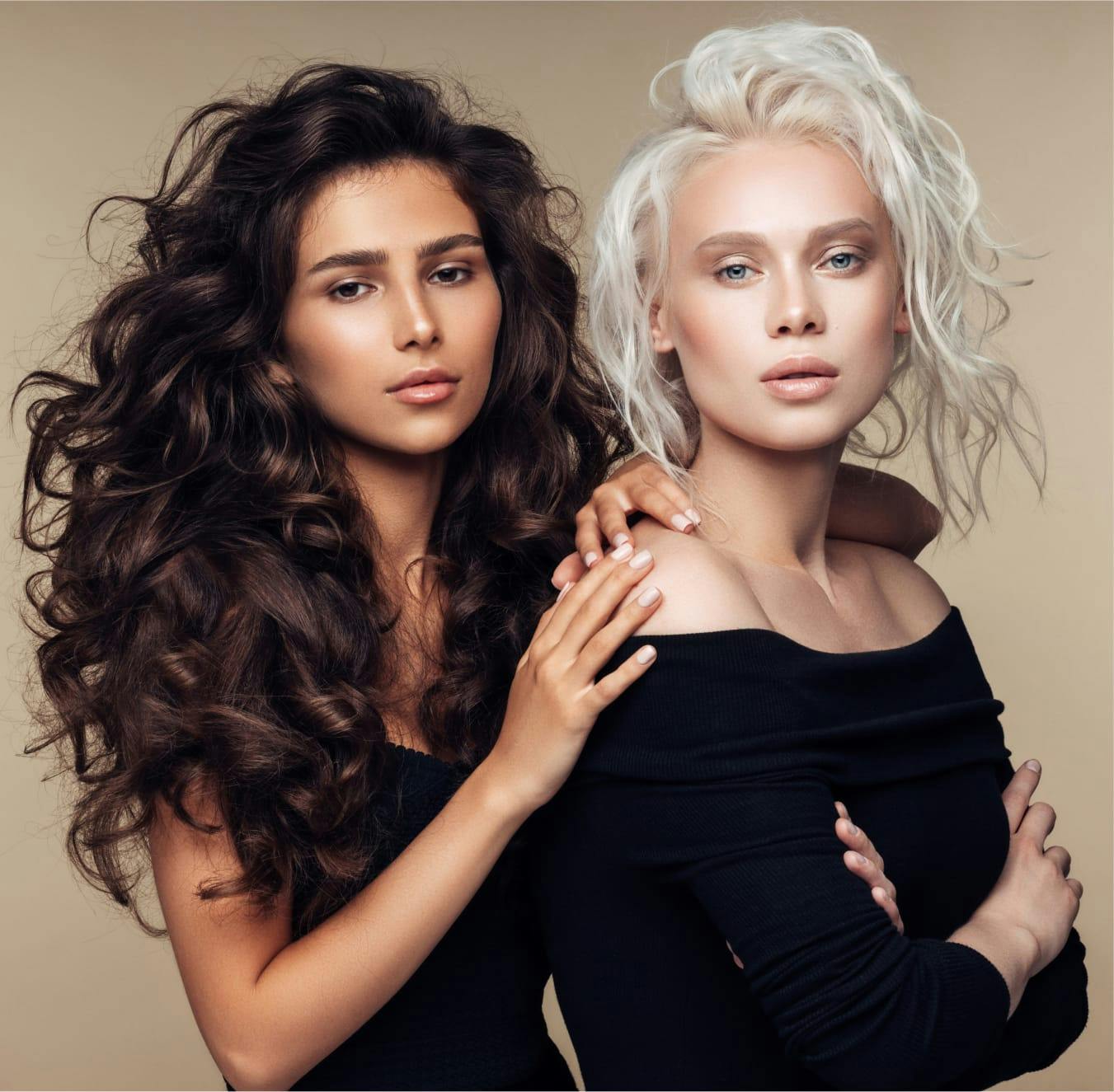 Two women posing towards camera