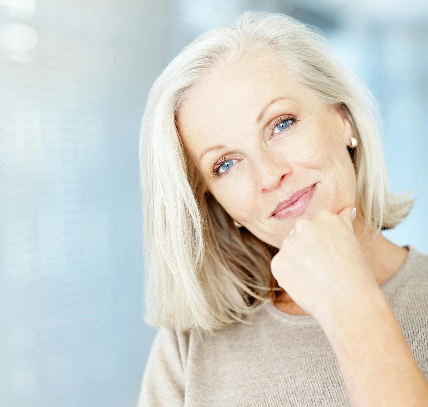 Older woman touching her face