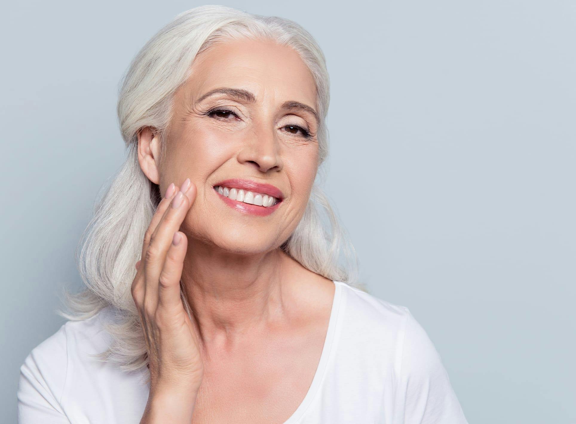 Older woman touching her face