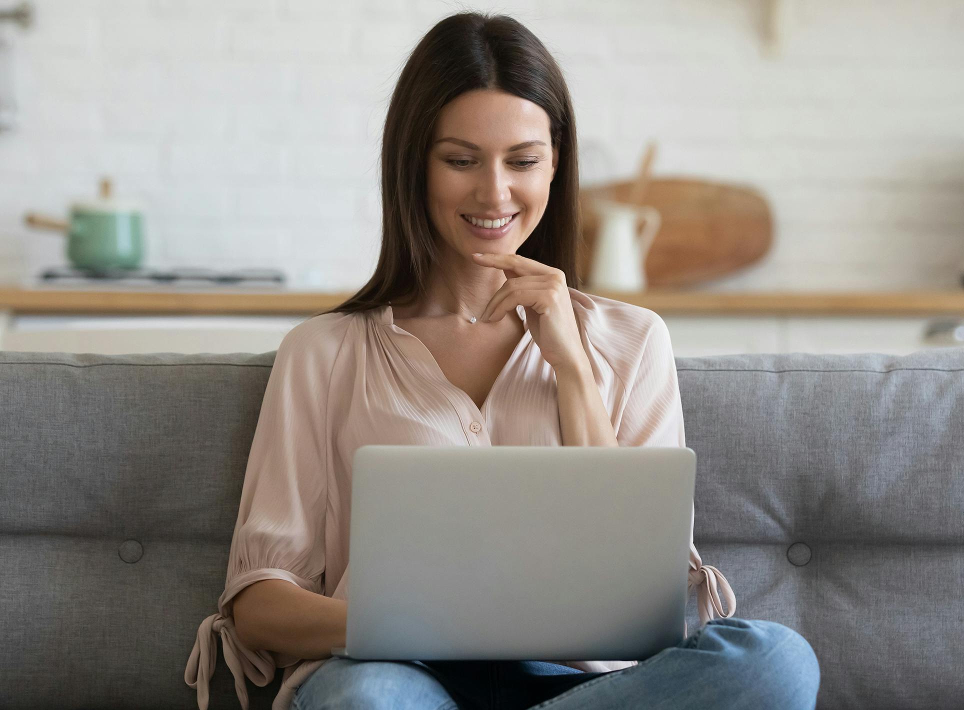 Woman sitting on couch with a laptop