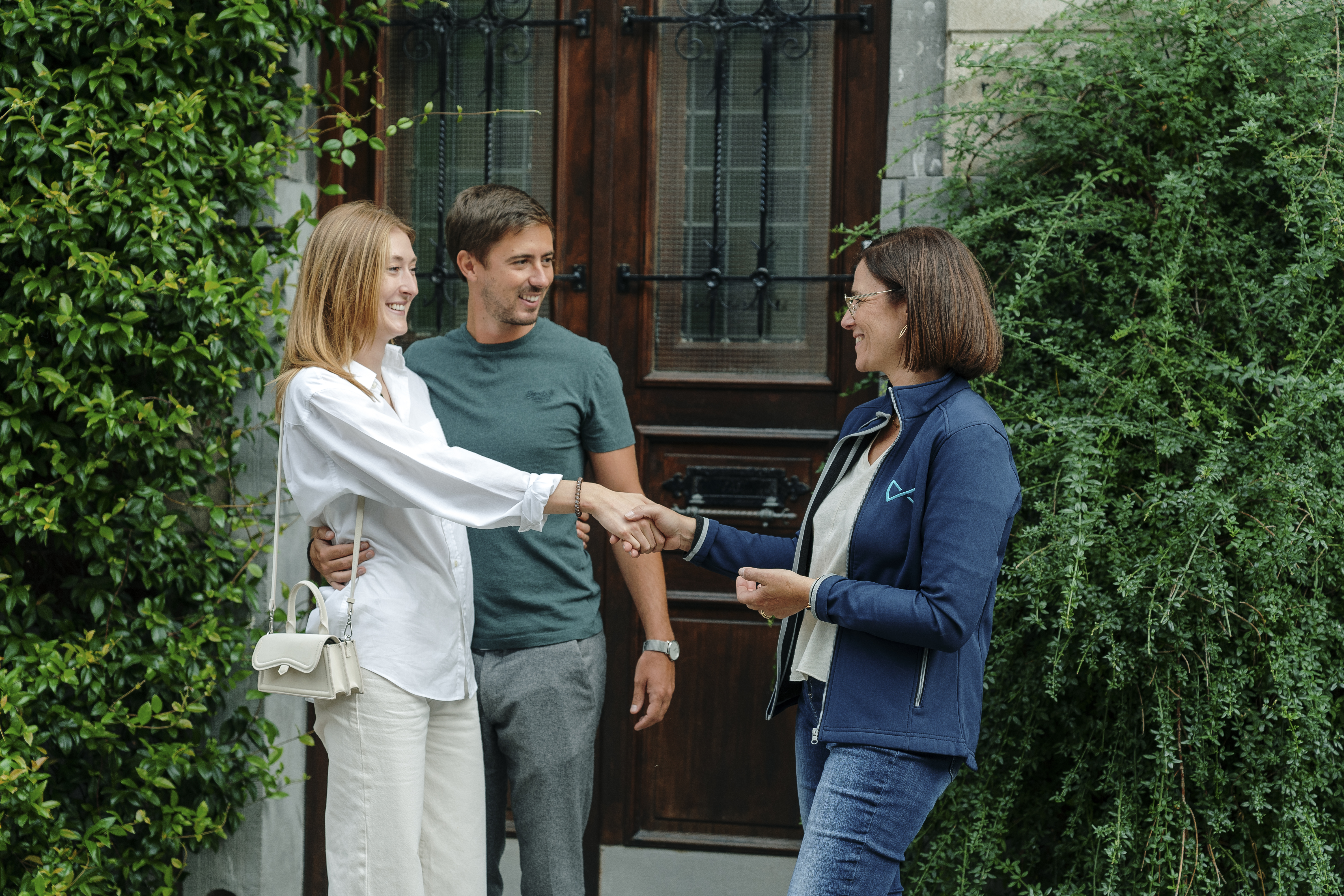 Poignée de mains entre acheteurs et agent immobilier