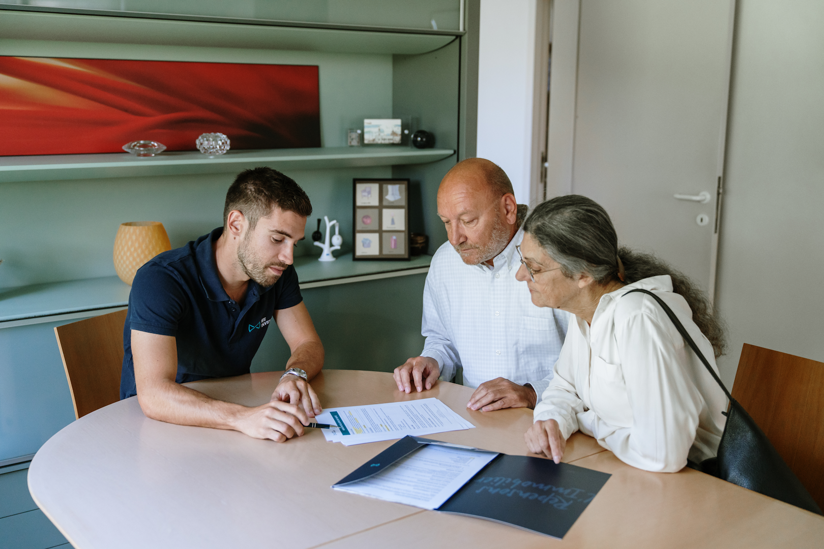 Un agent immobilier et ses clients qui regardent les différentes aides possibles pour rénover son bien