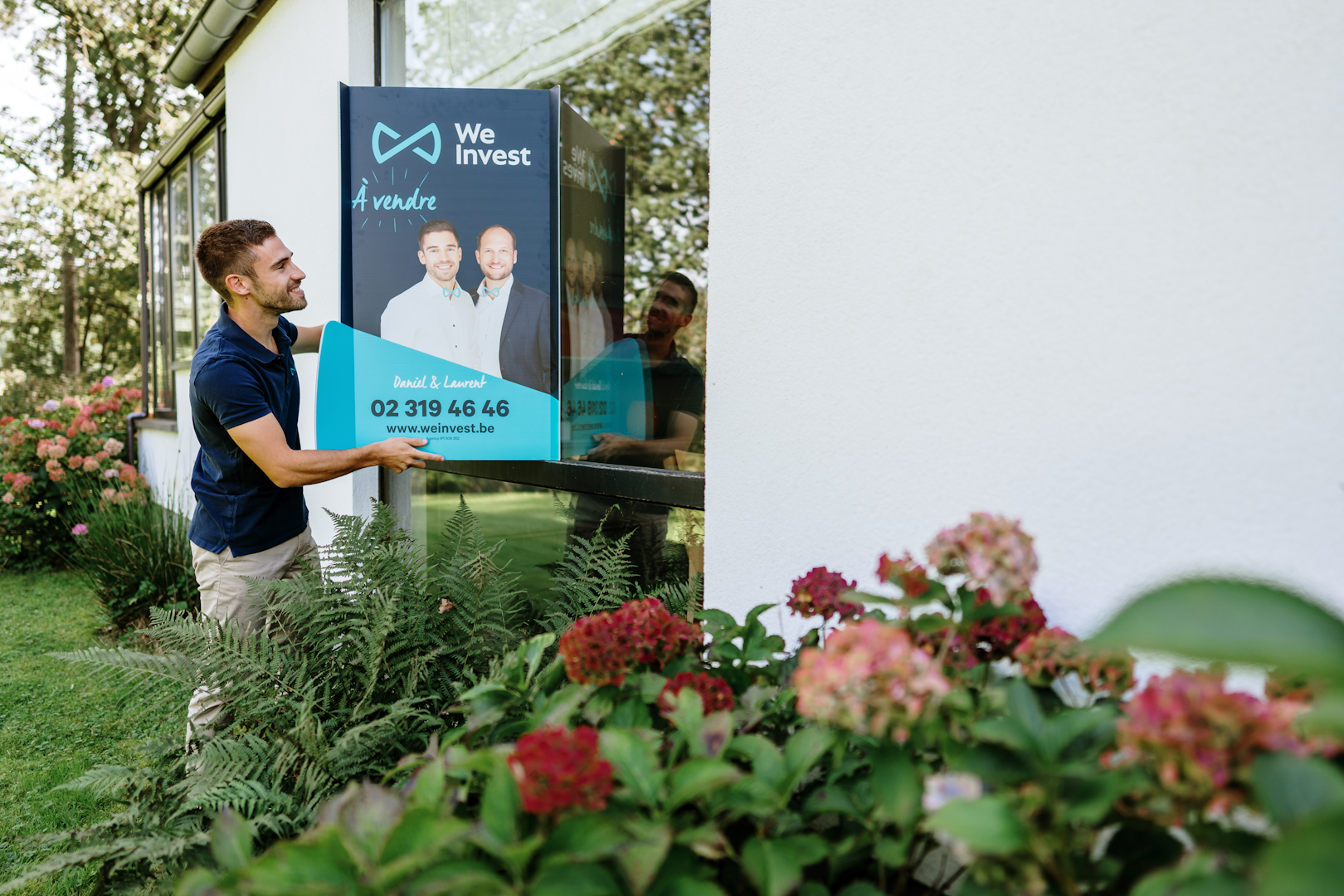 Agent immobilier qui pose un panneau